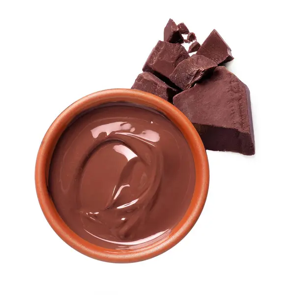 Tasty milk chocolate paste in bowl and pieces isolated on white, top view