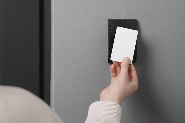 Женщина открывает магнитный замок картой-ключом, крупным планом. Безопасность дома