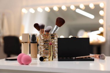 Makyaj odasındaki beyaz masada farklı kozmetik ürünleri.