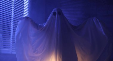 Ürkütücü hayalet. Pencerenin yanında, mavi ışıkla kaplanmış kadın.