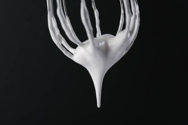 Siyah arka planda krem şantili çırpma çırpma, yakın plan