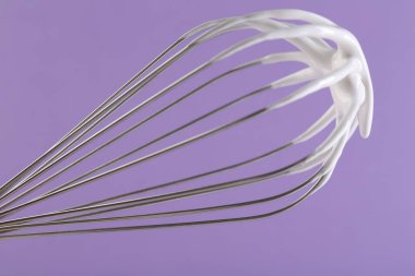 Menekşe arkaplanda çırpılmış krema, yakın plan.