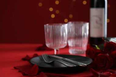 Kırmızı masada romantik bir akşam yemeği için güllerin olduğu yer, yakın plan. Metin için boşluk