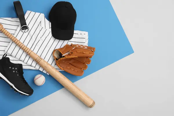Flat lay composition with baseball uniform and sports equipment on color background. Space for text