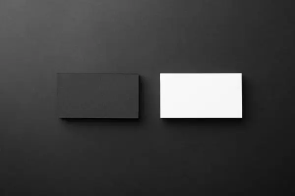 Blank business cards on black background, flat lay. Mockup for design