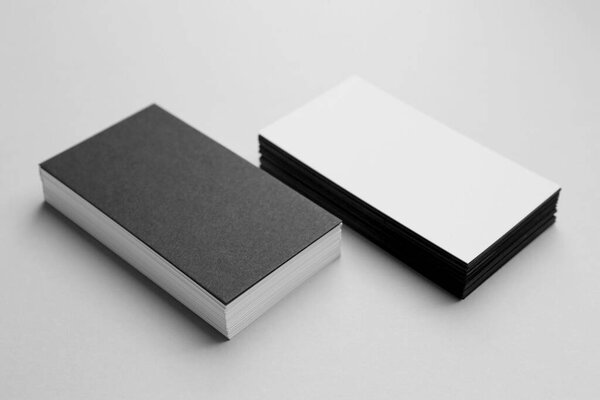 Blank black and white business cards on light background. Mockup for design