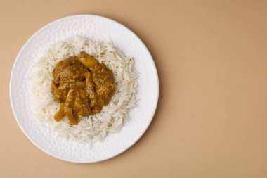 Bej arka planda pirinçli nefis körili tavuk, üst manzara. Metin için boşluk