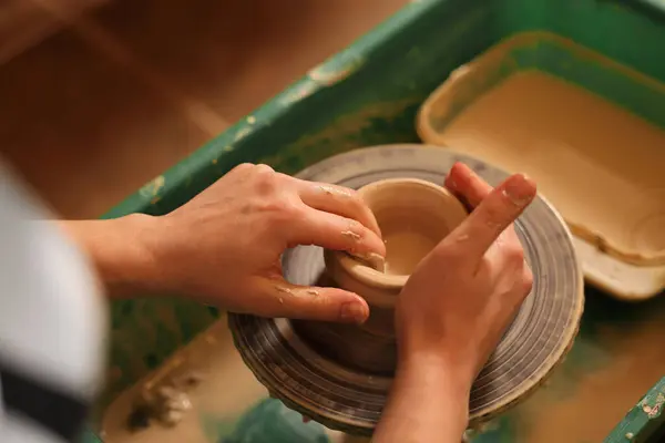 Clay crafting. Woman making bowl on potter\'s wheel, closeup