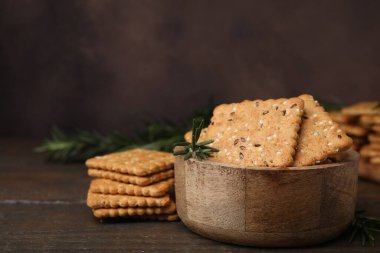 Tahta masadaki kasede keten, susam tohumu ve biberiye içeren mısır gevreği krakerleri, yakın plan. Metin için boşluk