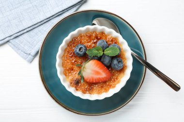 Böğürtlenli ve nane şekerli nefis creme brulee beyaz ahşap masa, üst manzara