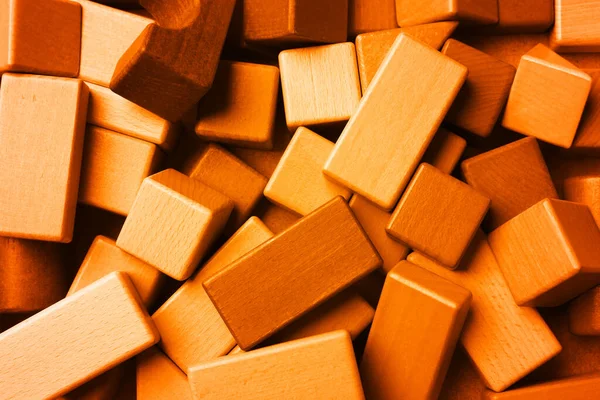 Orange wooden construction set as background, top view