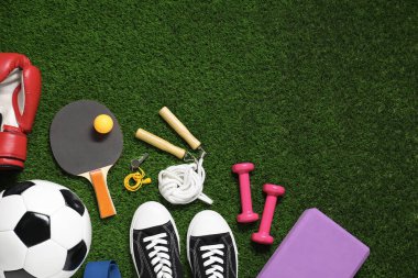 Yeşil çimlerde farklı spor aletleri, düz bir yerde. Metin için boşluk