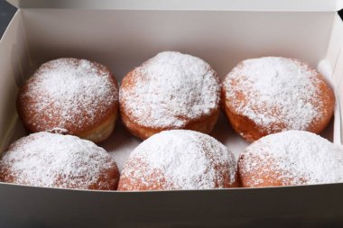 Kutuda pudra şekerli lezzetli çörekler, yakın plan.