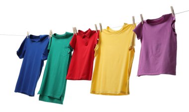 Çamaşır ipinde kurumuş renkli tişörtler beyazda izole edilmiş.