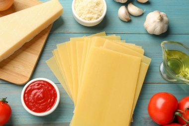 Lazanya malzemeleri mavi ahşap masada, düz yatıyordu.