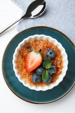 Böğürtlenli ve nane şekerli nefis creme brulee beyaz ahşap masa, üst manzara