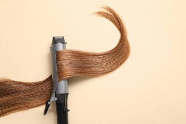 Saç maşası ve bej arka plan, üst manzara. Metin için boşluk