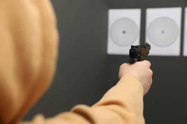 Man aiming at shooting target indoors, closeup