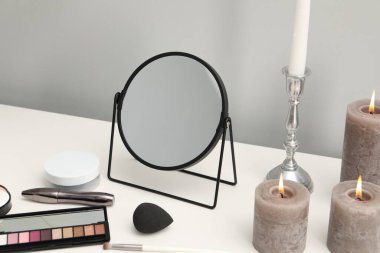 Aynalı makyaj masası, kozmetik ürünler ve makyaj odasında mum yakma.