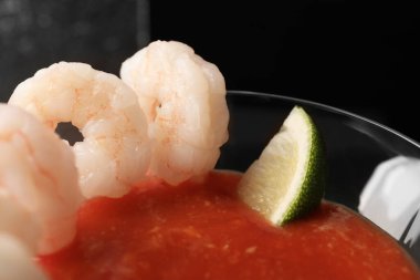 Sos ve limonlu lezzetli karides kokteyli koyu arka planda, yakın plan.