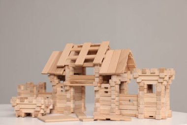 Tahta giriş kapısı ve gri arka plana karşı beyaz masanın üzerindeki yapı taşları. Çocuk oyuncağı.