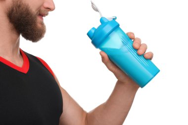 Beyaz arka planda protein karıştırıcısı tutan kaslı vücutlu genç adam, yakın plan.