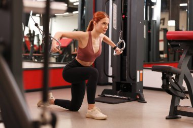 Modern spor salonunda spor yapan genç bir bayan.