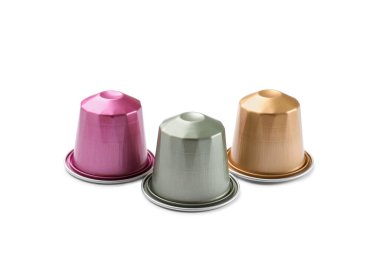 Beyaz üzerine izole edilmiş üç plastik kahve kapsülü.