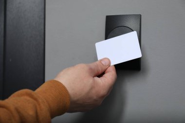 Manyetik kapı kilidini anahtar kartıyla açan adam, yakın plan. Ev güvenliği