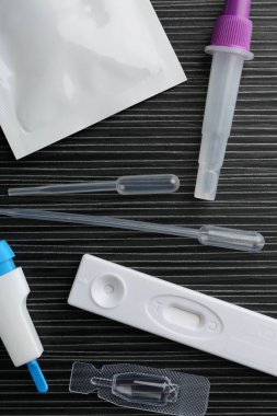 Siyah ahşap masada tek kullanımlık test kiti, düz yatıyordu.