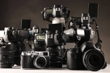 Beyaz masadaki modern kameralar koyu arkaplana karşı, yakın plan