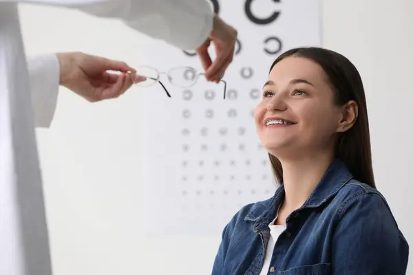 Teste Visão Oftalmologista Dando Óculos Para Jovem Mulher Dentro Casa — Fotografia de Stock