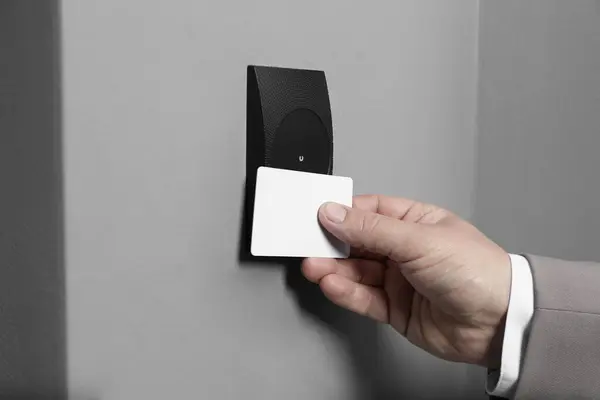 Man opening magnetic door lock with key card, closeup. Home security