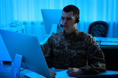 Askerlik. Kulaklıklı asker geceleri ofiste çalışıyor.