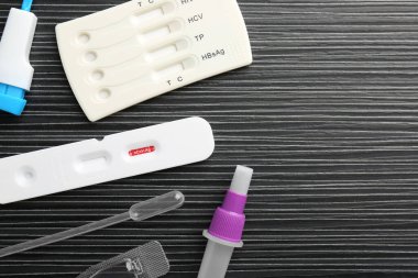 Siyah ahşap masada tek kullanımlık test kitleri, düz yatıyordu. Metin için boşluk