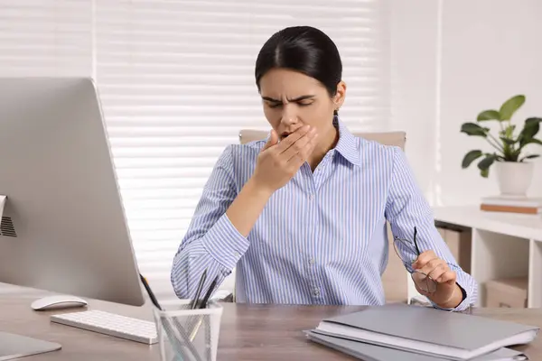 Woman coughing at table in office. Cold symptoms