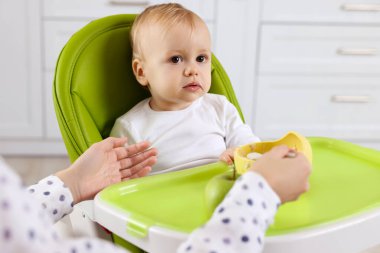 Anne, küçük bebeğini sağlıklı yiyeceklerle besliyor.