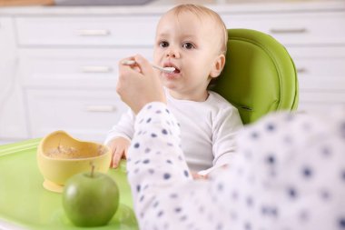 Anne, küçük bebeğini sağlıklı yiyeceklerle besliyor.