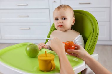 Anne, küçük bebeğini sağlıklı yiyeceklerle besliyor.