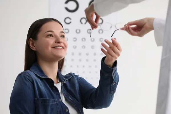 Test Wzroku Okulista Dający Okulary Młodej Kobiecie Pomieszczeniach — Zdjęcie stockowe