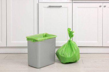 Mutfakta plastik çöp torbası ve çöp kutusu var.