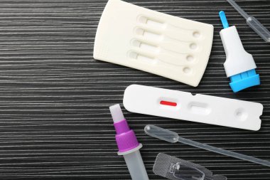 Siyah ahşap masada tek kullanımlık test kitleri, düz yatıyordu. Metin için boşluk