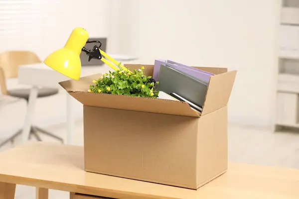 Unemployment problem. Box with worker\'s personal belongings on desk in office
