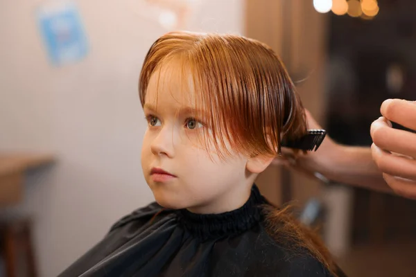 美容院 クローズアップで男の子の髪をコメディングプロの美容師 — ストック写真