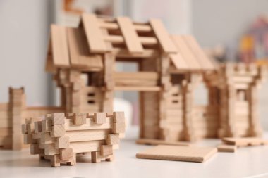 Tahta giriş kapısı ve beyaz masa üzerindeki yapı taşları, seçici odaklanma. Çocuk oyuncağı.