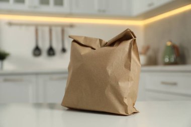 Mutfaktaki beyaz masada kağıt torba.