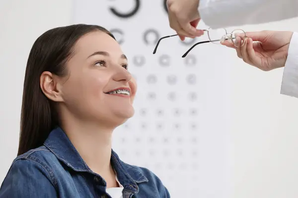 Teste Visão Oftalmologista Dando Óculos Para Jovem Mulher Dentro Casa — Fotografia de Stock