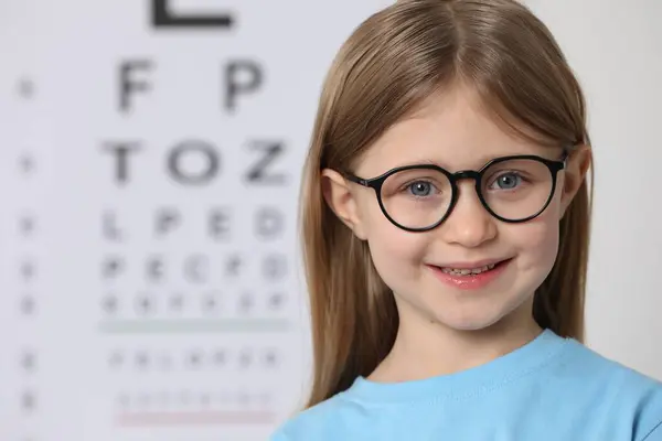 Dziewczynka Okularach Przeciwko Wykresowi Testu Wzroku — Zdjęcie stockowe