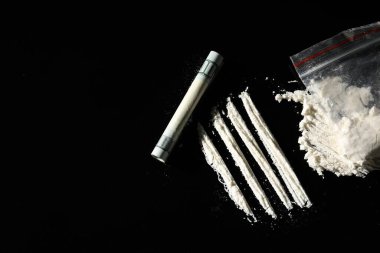 Sert uyuşturuculu plastik torba ve siyah arka planda yuvarlanan dolar banknotu. Metin için boşluk