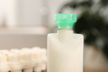 Bulanık arka planda mini bir şişe kozmetik ürünü, yakın plan. Metin için boşluk